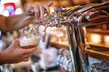 Glass of beer in pub, hand of bartender pouring a large lager beer in tap, the beer taps in a pub Royalty Free Stock Photo