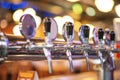 Glass of beer in pub, hand of bartender pouring a large lager beer in tap, the beer taps in a pub Royalty Free Stock Photo