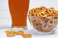 Glass of beer and salty mini pretzels in a deep glass bowl Royalty Free Stock Photo