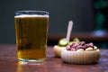 A glass of beer with snacks on a wooden table. Royalty Free Stock Photo