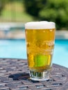 Glass of beer on table by poolside Royalty Free Stock Photo