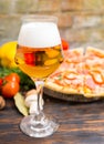 Glass of beer and tasty pizza with salami on background Royalty Free Stock Photo