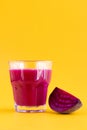 A glass of beetroot juice on a yellow background, a place for your text. Glass of vegetable juice, side view