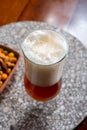 Glass of Belgian light blond beer made in abbey and bowl with party mix nuts Royalty Free Stock Photo