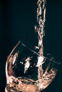 A glass on a black background, an olive drops in a glass with splashes