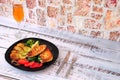 Glass black plate with two chicken fillet steaks, fresh tomatoes, peeled potatoes, zucchini, mushrooms and broccoli Royalty Free Stock Photo