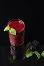 Glass of blackberry smoothie on black background. Healthy drink. Royalty Free Stock Photo