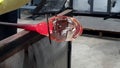 Glass blower process jacking to shape up at working bench artistic craftmanship