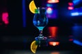 Glass of blue alcohol cocktail Martini with a slice of orange party at bar Royalty Free Stock Photo