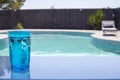 glass of blue water in front of the pool, summer image, pastel colors Royalty Free Stock Photo