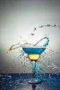 Glass with blue and yellow champagne or cocktail. Levitation Royalty Free Stock Photo