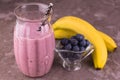 A glass of blueberry banana smoothie on a gray background. Close-up. Royalty Free Stock Photo