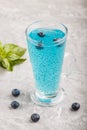 Glass of blueberry blue colored drink with basil seeds on a gray concrete background.  Side view Royalty Free Stock Photo