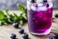 Glass of blueberry lavender lemonade with blueberries, lavender sprigs, and ice cubes, garnished with a lemon slice on Royalty Free Stock Photo