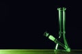 Glass bong on wooden table against black background, space for text. Smoking device Royalty Free Stock Photo