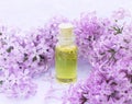 Glass bottle with aromatic yellow oil and lilac flowers for Spa and aromatherapy. Electoral focus