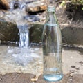 Glass bottle on the background of pure spring water. Pure natural water Royalty Free Stock Photo