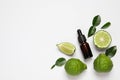 Glass bottle of bergamot essential oil and fresh fruits on white background, flat lay. Space for text Royalty Free Stock Photo