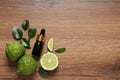 Glass bottle of bergamot essential oil and fresh fruits on wooden table, flat lay. Space for text Royalty Free Stock Photo