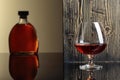 Glass and bottle of brandy on a black reflective background Royalty Free Stock Photo