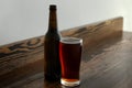 Glass and bottle of cold beer on wooden table Royalty Free Stock Photo