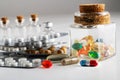 glass bottle with colorful vitamins and pill packs on a white table. close-up