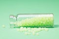 glass bottle with cork with green granules on a green background Royalty Free Stock Photo