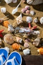 A glass bottle with a letter washed up on the beach shore. Sea beach full of shells and sand. Beach slippers Royalty Free Stock Photo