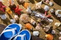 A glass bottle with a letter washed up on the beach shore. Sea beach full of shells and sand. Beach slippers Royalty Free Stock Photo