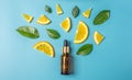 Glass bottle with cosmetic oil and orange leaves and slices on a blue background Royalty Free Stock Photo