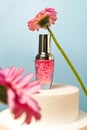 Cosmetic Serum with pink granules on Blue Background. Pedestal product display creative concept with flowers Royalty Free Stock Photo