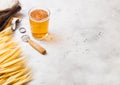 Glass and bottle of craft lager beer with raw wheat and opener on stone kitchen table background. Space for text. Top view Royalty Free Stock Photo