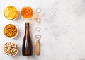 Glass and bottle of craft lager beer with snack and opener on stone kitchen table background. Pretzel and crisps and pistachio in Royalty Free Stock Photo