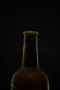 A glass bottle of dark beer on a black background Royalty Free Stock Photo