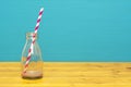 Glass bottle with dregs of chocolate milkshake and a straw