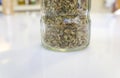 Glass bottle of dry oregano leaves Royalty Free Stock Photo