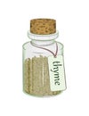 Glass bottle with dry thyme leaves and a label with the name of the spice Royalty Free Stock Photo
