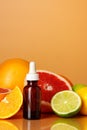 Glass bottle with essential citrus oil on orange background Royalty Free Stock Photo