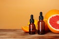 Glass bottle with essential citrus oil on orange background Royalty Free Stock Photo