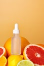 Glass bottle with essential citrus oil on orange background Royalty Free Stock Photo