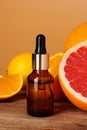 Glass bottle with essential citrus oil on orange background Royalty Free Stock Photo