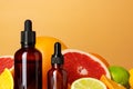 Glass bottle with essential citrus oil on orange background Royalty Free Stock Photo