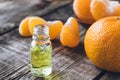 A glass bottle of essential oil with mandarin and slices of ripe mandarin are on the table Royalty Free Stock Photo