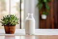 A glass bottle of fresh milk in a modern-style kitchen with live green plants.