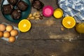 Glass bottle of fresh orange juice with fresh fruits and almond, hazelnuts and homemade chocolate muffins on wooden table