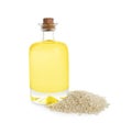 Glass bottle with fresh sesame oil and seeds isolated on white