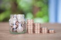 Glass bottle full of dollar coins and a row of declining dollar coins Royalty Free Stock Photo