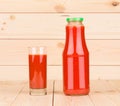Glass and bottle full of tomato juice.