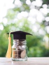 Glass bottle with graduation hat. The concept of saving money for education, student loan, scholarship, tuition fees in future Royalty Free Stock Photo