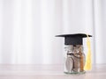 Glass bottle with graduation hat. The concept of saving money for education, student loan, scholarship, tuition fees in future Royalty Free Stock Photo